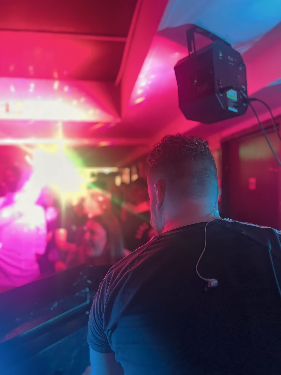 Volle dansvloer in roze en rood licht tijdens een feest